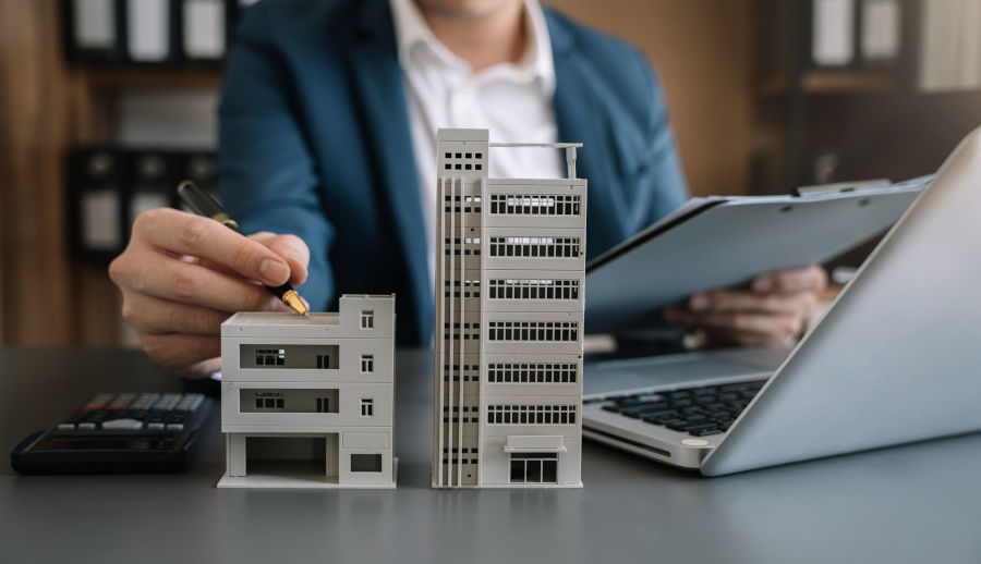 person on a laptop, small building on table