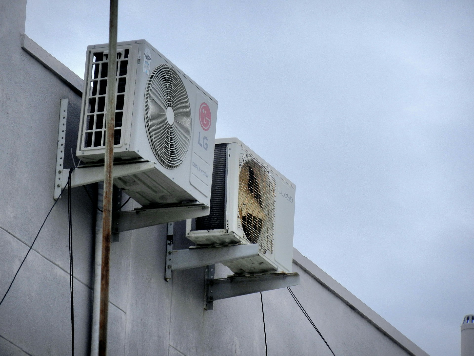An air conditioner unit mounted on the exterior wall of a building. Image by Unsplash
