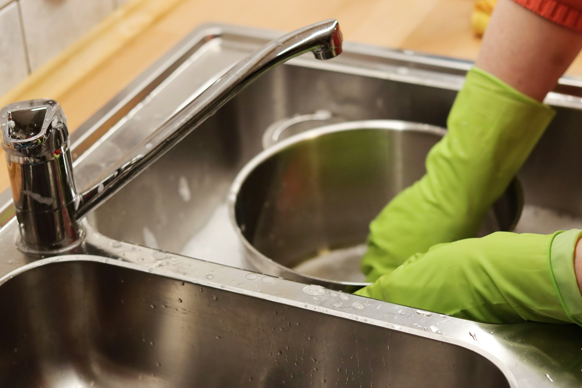 Person washing a pot in a sink. Image by Unsplash