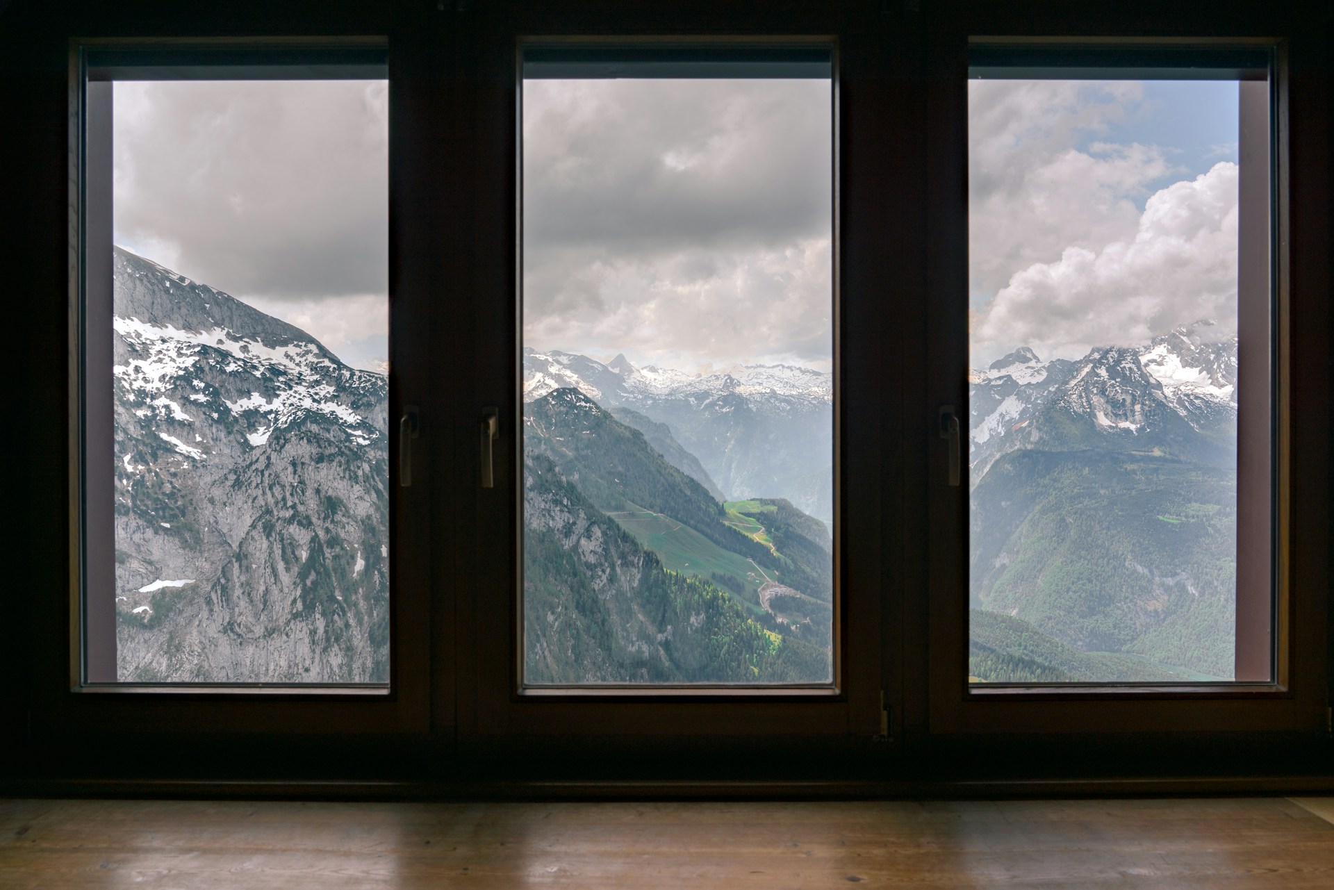 Fog covered smow capped mountain range view outside three large windows. Image by Unsplash