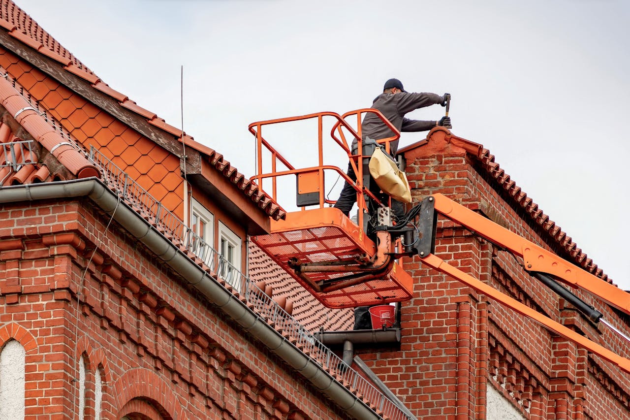 Roofing maintenance, brick building. Image by Pexels