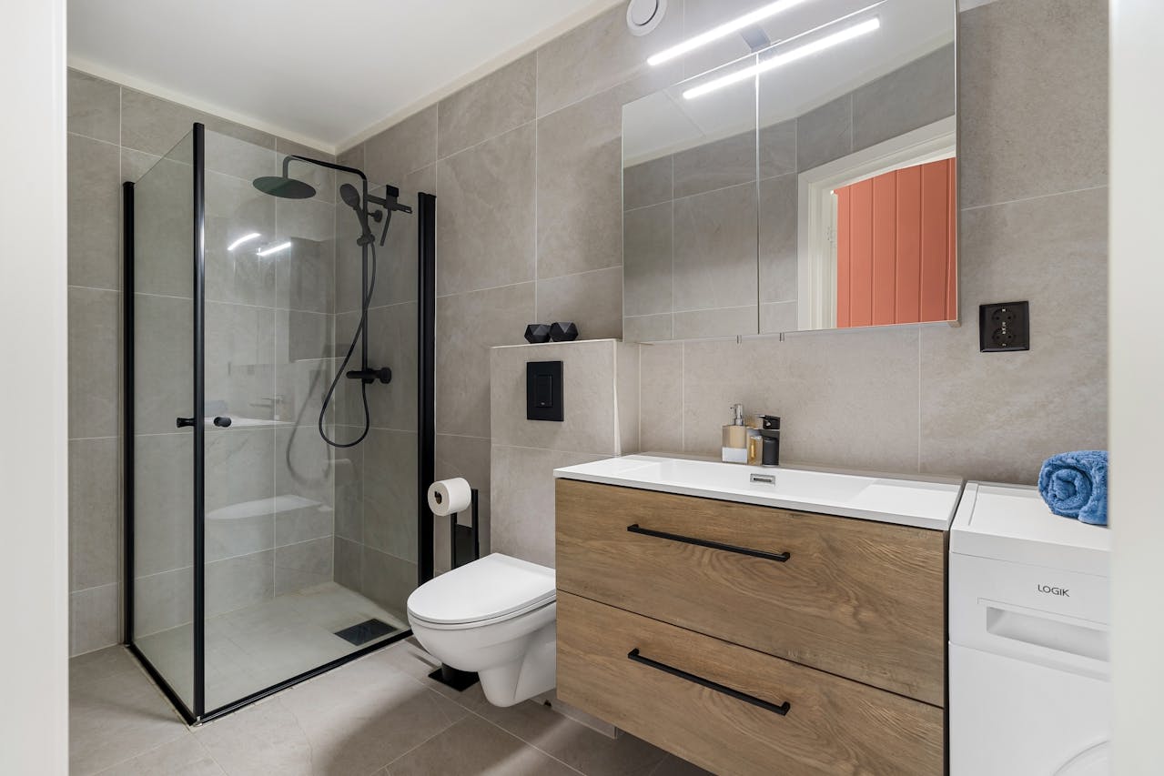 Interior of a bathroom, glass shower doors. Image by Pexels