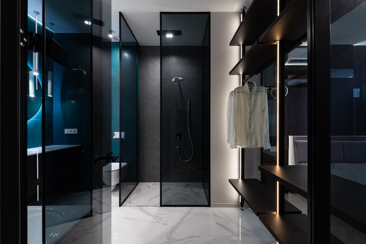 Wardrobe and a bathroom with glass walls in modern bedroom. Image by Pexels