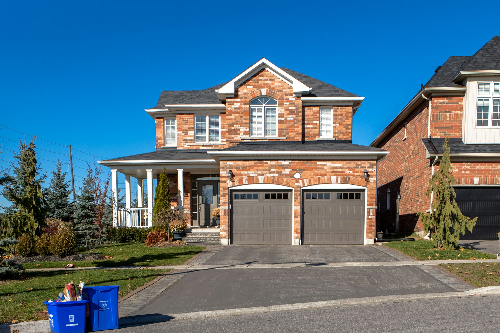 A modern brick house with a clean driveway under a blue sky. Image by Unsplash