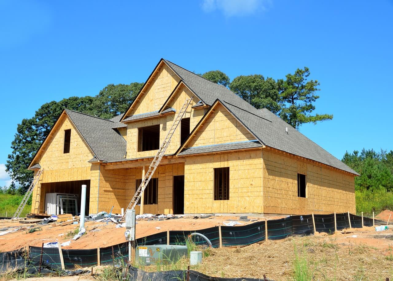 House construction, ladder leaning against the house, trees in the background, blue sky. Image by Pixabay