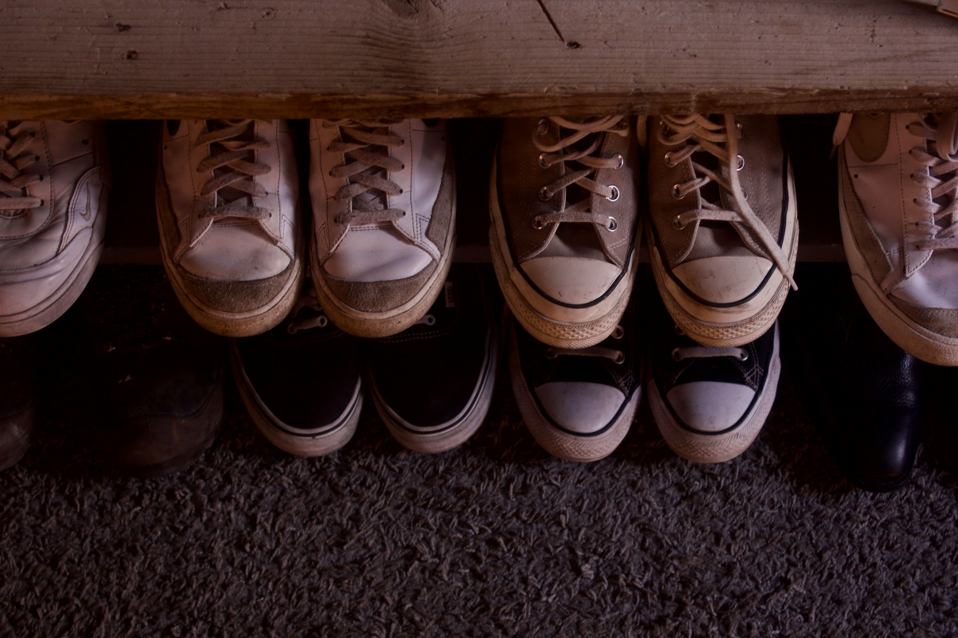 Shoes on floor and an a wooden bench. Image by Unsplash