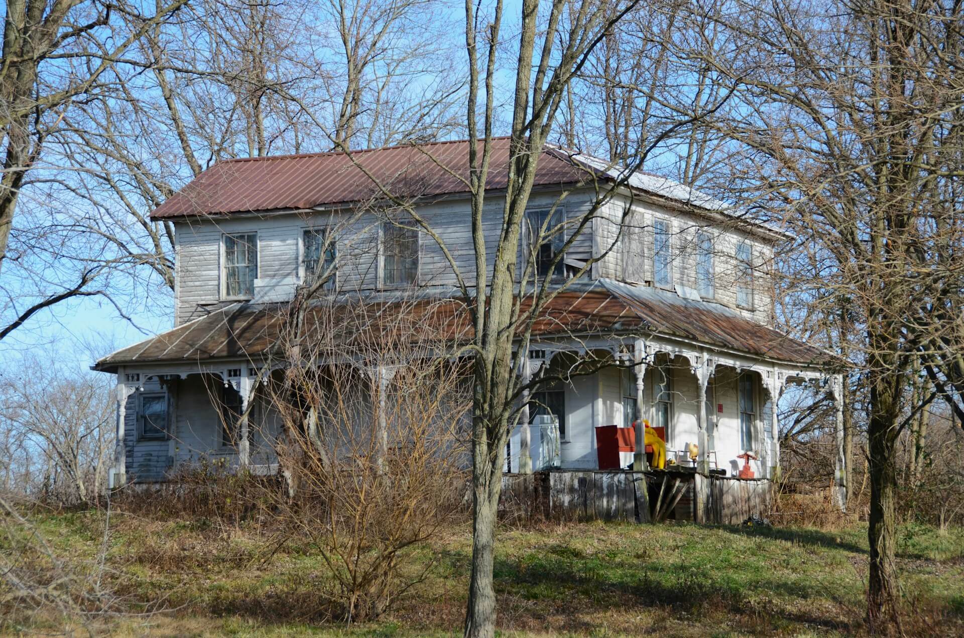 White house with a two car garage with trees behind the house. Image by Unsplash