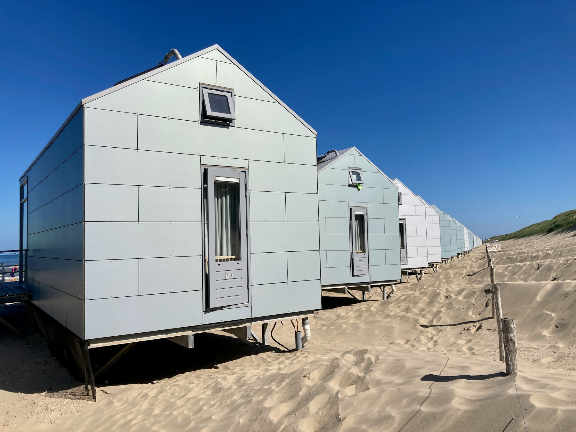 white concrete houses on a beach, blue sky. Image by Unsplash