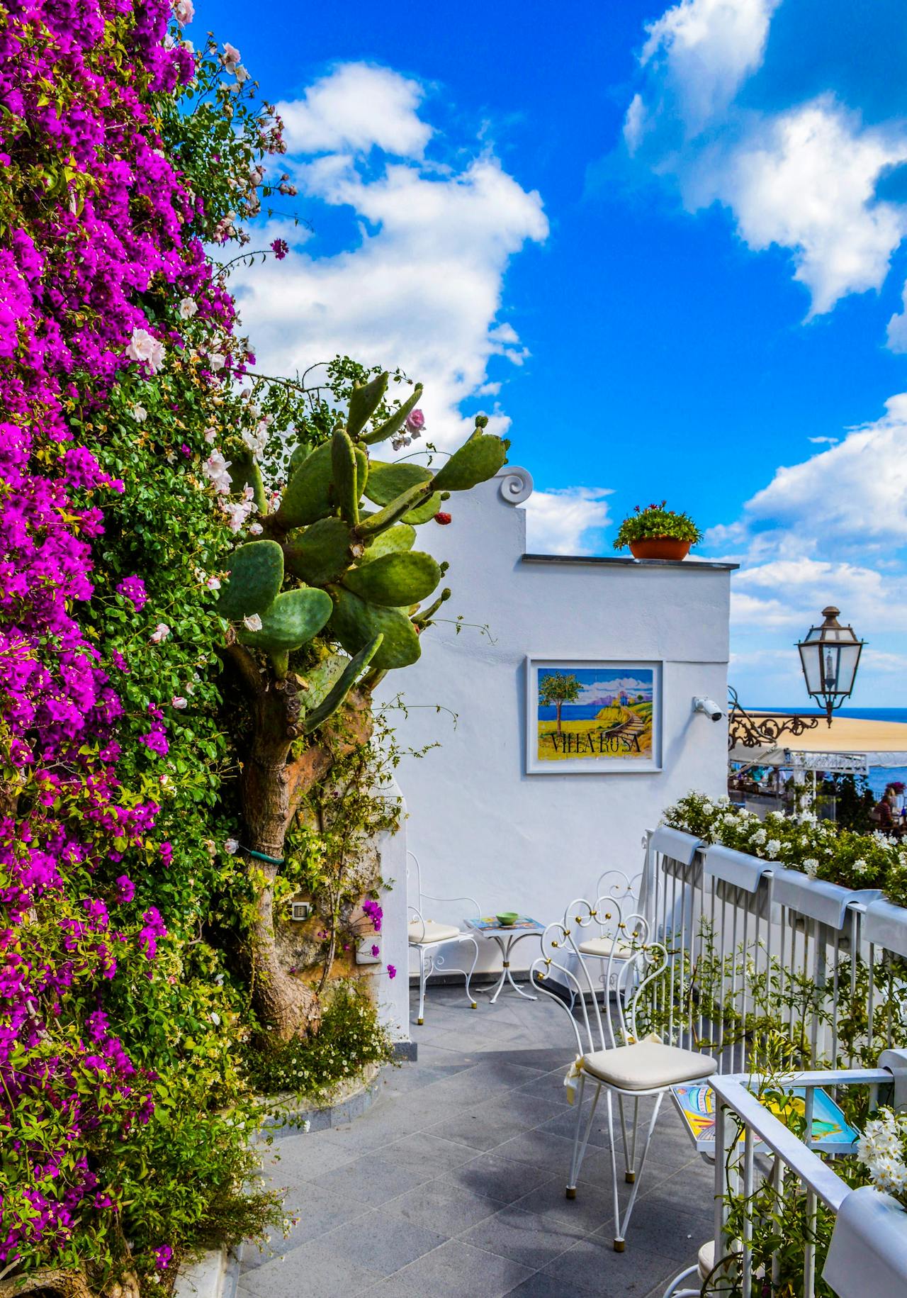 Small balcony, white house, pink flowers