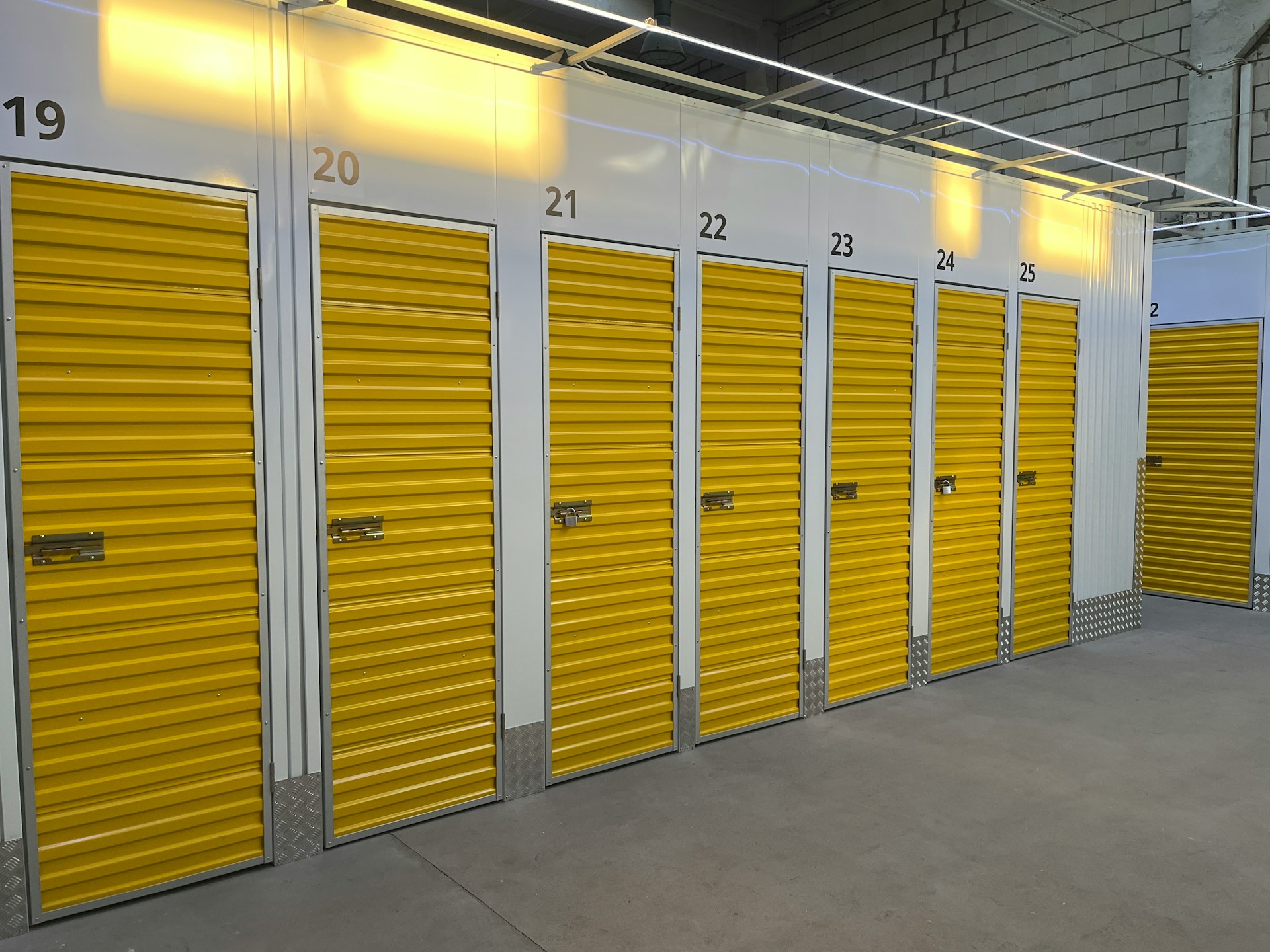 Yellow door storage units numbered from 19-25. Image by Unsplash