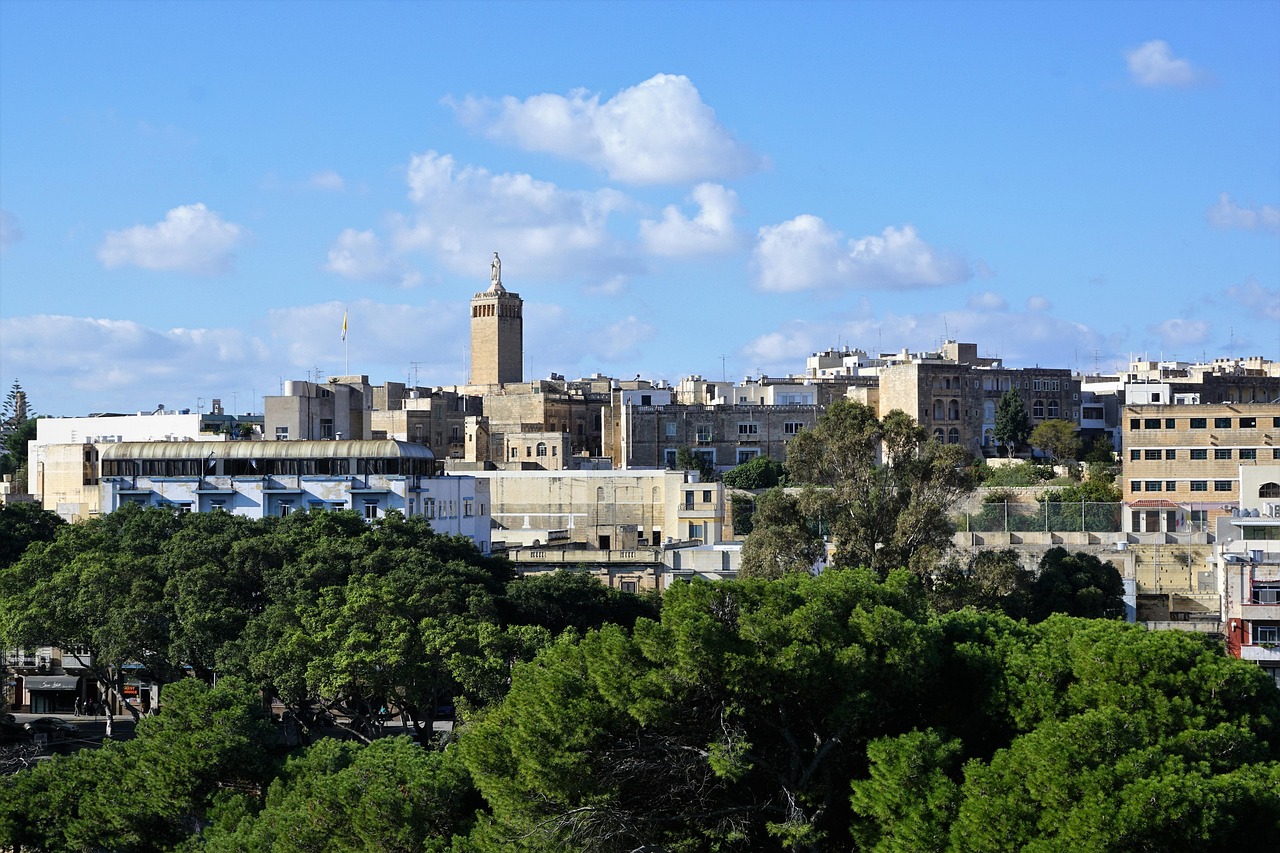 trees, buildings, blue sky with clouds. Image by Pixabay