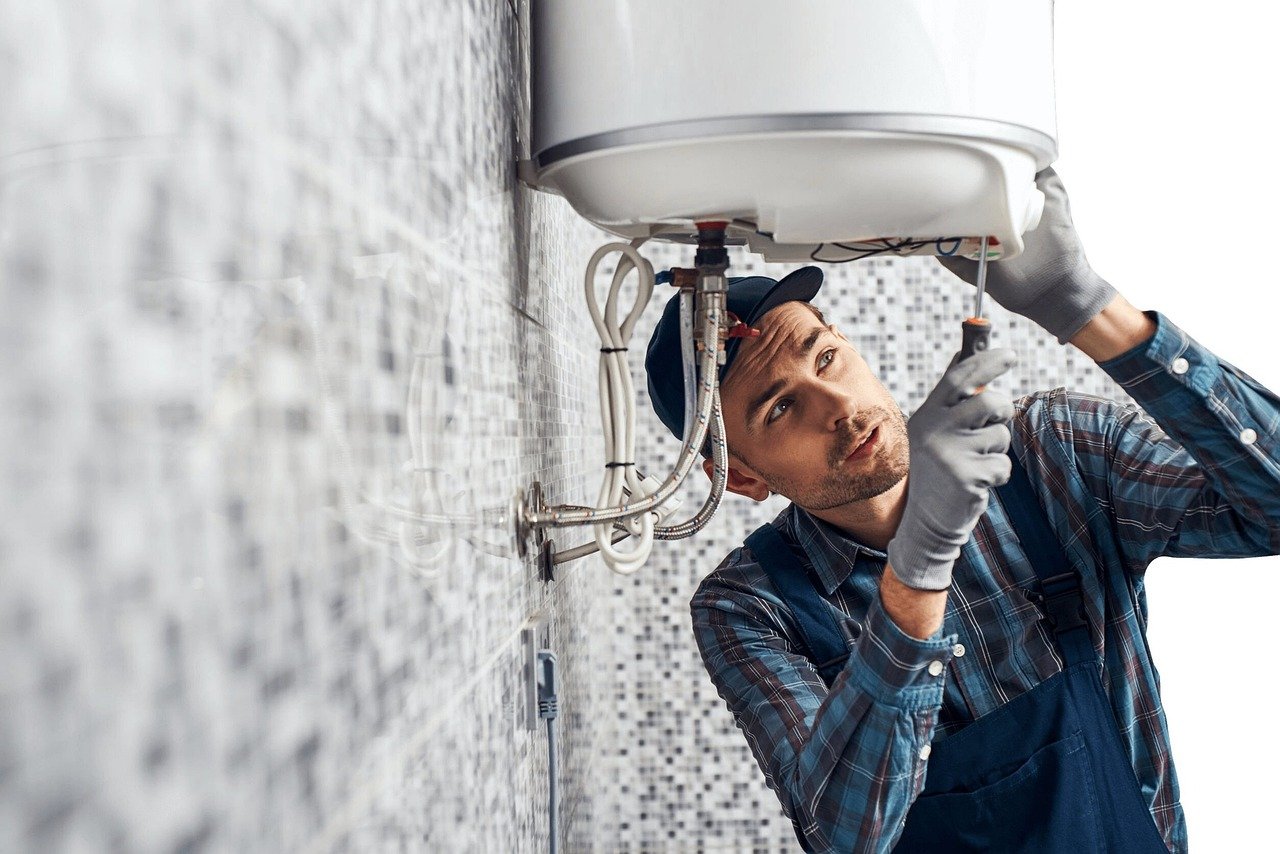 Plumber working under a sink. Image by Pixabay