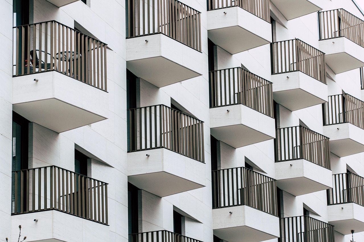 White apartment building with lots of balconies. Image by Pixabay