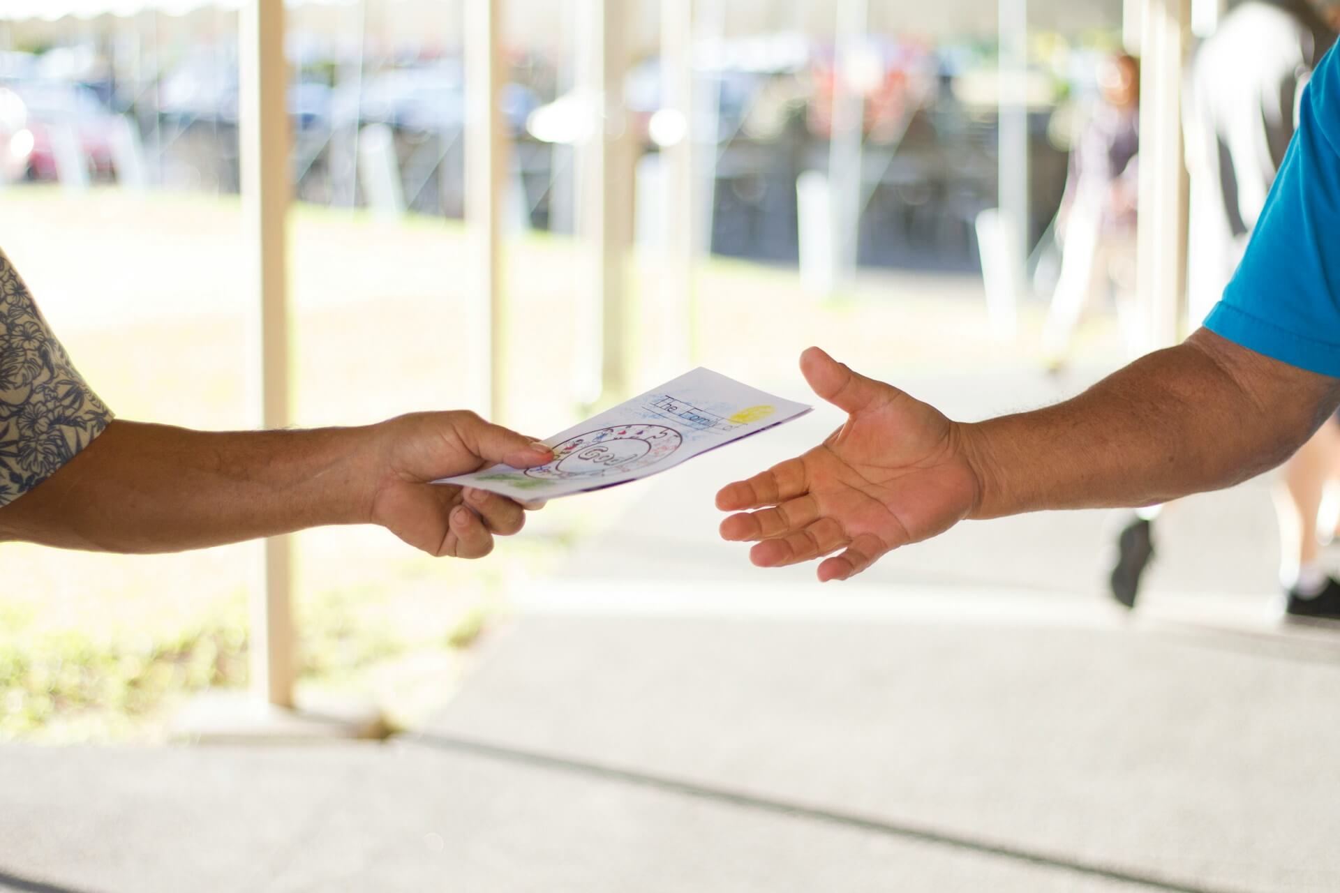 Person handong out a card. Image by Unsplash
