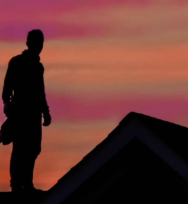 Silhouette of a man standing on a roof. Image by Unsplash