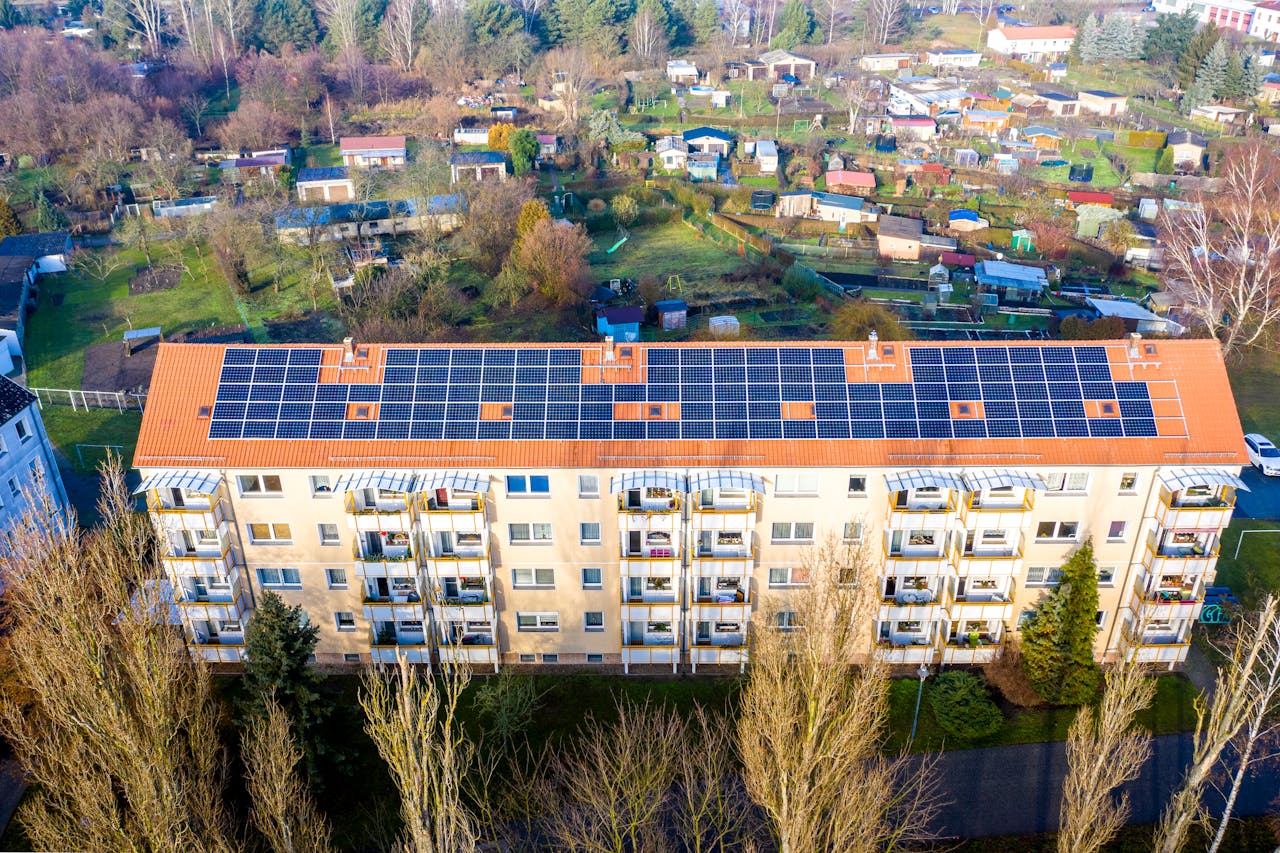 Large apartment building with solar panels on the roof. Image by Pexels