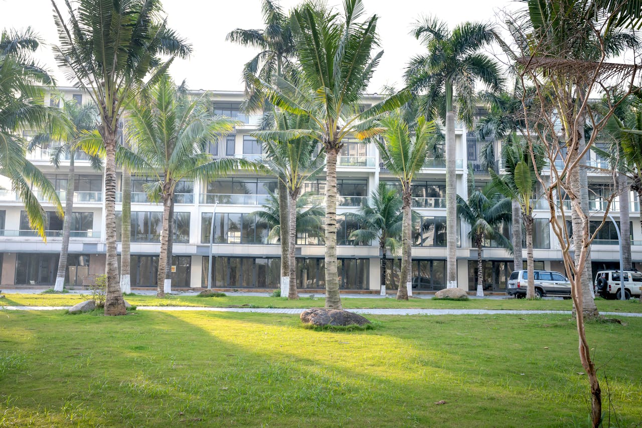 Large apartment building with lots of palm trees in front of it. Image by Pexels
